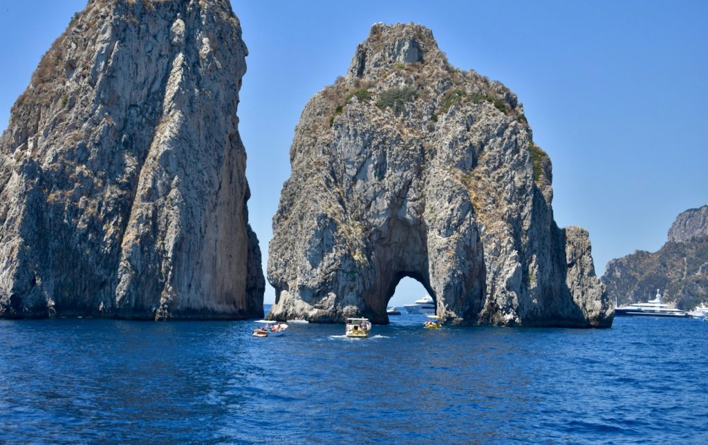 a group of people in boat in front of a rock formation capri tour