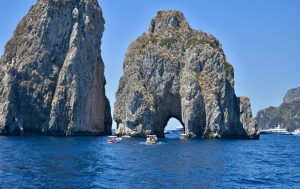 a group of people in boat in front of a rock formation capri tour